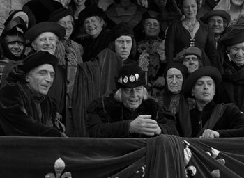 Movie still from “The Hunchback of Notre Dame” (1939), directed by William Dieterle – A group of old people sitting next to each other; Medium shot, High angle