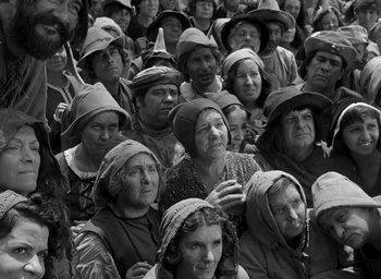 Movie still from “The Hunchback of Notre Dame” (1939), directed by William Dieterle – A group of people wearing hats in a crowd; Wide shot, High angle