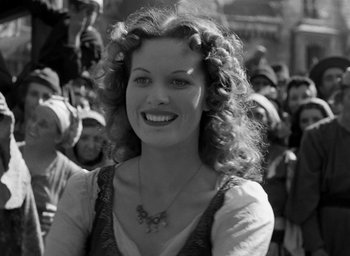 Movie still from “The Hunchback of Notre Dame” (1939), directed by William Dieterle – A beautiful woman with curly hair smiling for the camera; Close Up shot, High angle