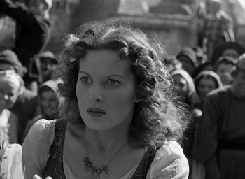 Movie still from “The Hunchback of Notre Dame” (1939), directed by William Dieterle – A black and white photo of a woman in front of a group of people; Close Up shot, Low angle