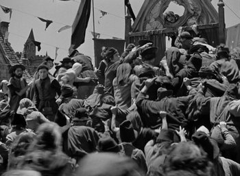 Movie still from “The Hunchback of Notre Dame” (1939), directed by William Dieterle – A crowd of people standing around a building; Wide shot, High angle