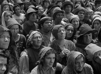 Movie still from “The Hunchback of Notre Dame” (1939), directed by William Dieterle – A group of people wearing hats sitting in a crowd; Wide shot, High angle