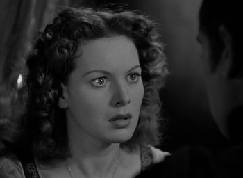 Movie still from “The Hunchback of Notre Dame” (1939), directed by William Dieterle – A black - and - white photo of a woman with curly hair; Close Up shot, Over the shoulder angle