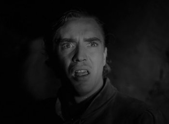 Movie still from “The Hunchback of Notre Dame” (1939), directed by William Dieterle – A black and white photo of a man making a funny face; Close Up shot, Low angle