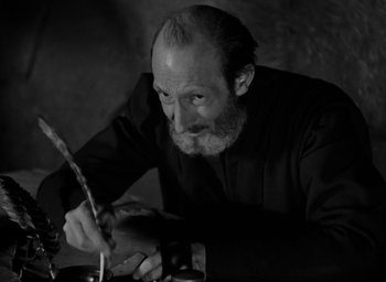 Movie still from “The Hunchback of Notre Dame” (1939), directed by William Dieterle – An older man writing with a quill pen; Close Up shot, Low angle