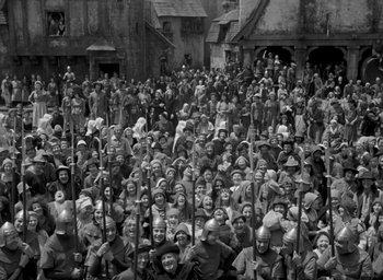 Movie still from “The Hunchback of Notre Dame” (1939), directed by William Dieterle – A large group of people standing in front of a building; Wide shot, High angle