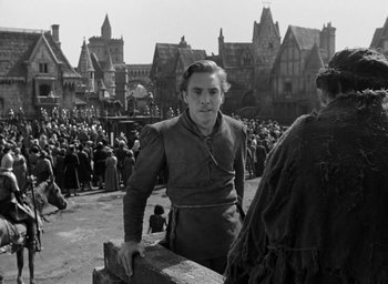 Movie still from “The Hunchback of Notre Dame” (1939), directed by William Dieterle – A man standing in front of a crowd of people; Medium shot, Over the shoulder angle