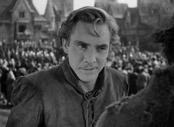 Movie still from “The Hunchback of Notre Dame” (1939), directed by William Dieterle – Black and white photograph of a man in a crowd of people; Close Up shot, Over the shoulder angle