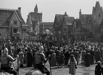 Movie still from “The Hunchback of Notre Dame” (1939), directed by William Dieterle – A crowd of people in medieval garb in front of a castle; Extreme Wide shot, High angle