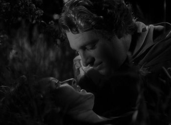 Movie still from “The Hunchback of Notre Dame” (1939), directed by William Dieterle – A black and white photo of a man and a woman kissing; Close Up shot, High angle
