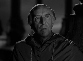 Movie still from “The Hunchback of Notre Dame” (1939), directed by William Dieterle – An old man wearing a monk's robe and a cap; Close Up shot, Low angle