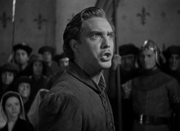 Movie still from “The Hunchback of Notre Dame” (1939), directed by William Dieterle – A black and white photo of a man in a crowd of people; Medium shot, Low angle
