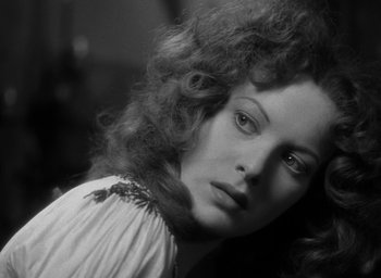 Movie still from “The Hunchback of Notre Dame” (1939), directed by William Dieterle – A black - and - white photo of a woman in a white dress; Close Up shot, Over the shoulder angle