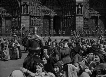 Movie still from “The Hunchback of Notre Dame” (1939), directed by William Dieterle – A group of people gathered in front of a building; Extreme Wide shot, High angle