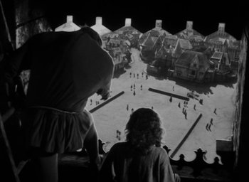 Movie still from “The Hunchback of Notre Dame” (1939), directed by William Dieterle – Two people looking out over a town from a balcony; Extreme Wide shot, High angle