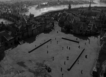 Movie still from “The Hunchback of Notre Dame” (1939), directed by William Dieterle – An aerial view of an old town with people walking around; Extreme Wide shot, High angle