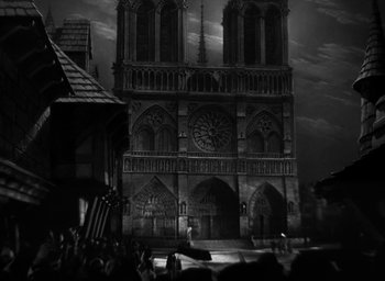 Movie still from “The Hunchback of Notre Dame” (1939), directed by William Dieterle – A black - and - white photo of a large cathedral; Extreme Wide shot, High angle