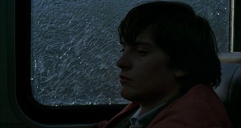 Movie still from “The Ice Storm” (1997), directed by Ang Lee – A man sitting in front of a rain covered window; Close Up shot, Low angle