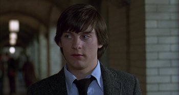 Movie still from “The Ice Storm” (1997), directed by Ang Lee – A man in a suit and tie looking at the camera; Close Up shot, Over the shoulder angle