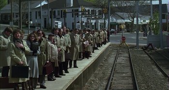 Movie still from “The Ice Storm” (1997), directed by Ang Lee – A group of men in trench coats standing next to railroad tracks; Wide shot, High angle
