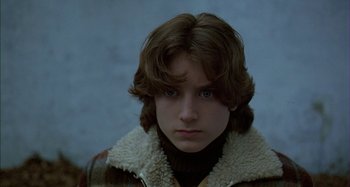 Movie still from “The Ice Storm” (1997), directed by Ang Lee – A young man with brown hair wearing a brown jacket; Close Up shot, Low angle