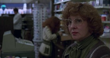 Movie still from “The Ice Storm” (1997), directed by Ang Lee – A woman in a store with glasses on her head; Close Up shot, Low angle
