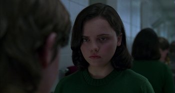 Movie still from “The Ice Storm” (1997), directed by Ang Lee – A young girl looking at a man in a green sweater; Close Up shot, Over the shoulder angle