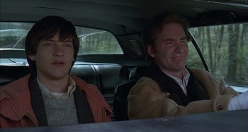 Movie still from “The Ice Storm” (1997), directed by Ang Lee – Two men sitting in the back seat of a car; Medium shot, Low angle