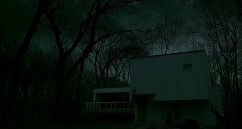 Movie still from “The Ice Storm” (1997), directed by Ang Lee – A building in the middle of the night with trees in the background; Extreme Wide shot, Low angle