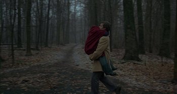 Movie still from “The Ice Storm” (1997), directed by Ang Lee – A man carrying a woman in a red backpack; Wide shot, Low angle