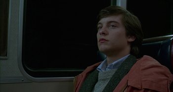 Movie still from “The Ice Storm” (1997), directed by Ang Lee – A young man sitting on a train looking up; Close Up shot, Low angle