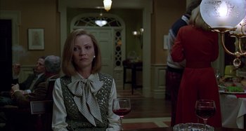 Movie still from “The Ice Storm” (1997), directed by Ang Lee – A woman sitting in front of a glass of wine; Medium shot, Over the shoulder angle