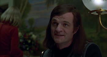 Movie still from “The Ice Storm” (1997), directed by Ang Lee – A man with long brown hair wearing a black sweater; Close Up shot, Over the shoulder angle