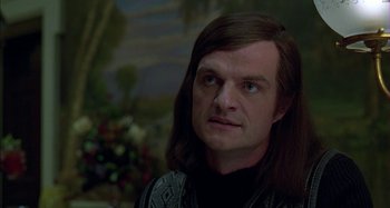 Movie still from “The Ice Storm” (1997), directed by Ang Lee – A man with long brown hair wearing a black shirt; Close Up shot, Over the shoulder angle