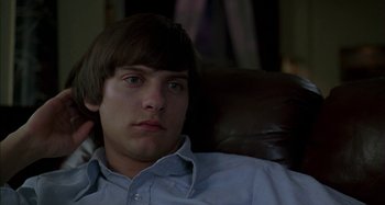 Movie still from “The Ice Storm” (1997), directed by Ang Lee – A man sitting in a chair looking at the camera; Close Up shot, High angle