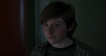 Movie still from “The Ice Storm” (1997), directed by Ang Lee – A young boy with a brown shirt is looking at the camera; Close Up shot, High angle