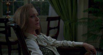 Movie still from “The Ice Storm” (1997), directed by Ang Lee – A woman sitting in a chair wearing a dress shirt and tie; Close Up shot, Low angle