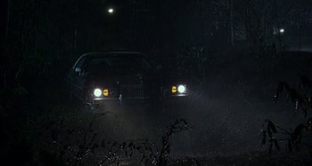 Movie still from “The Ice Storm” (1997), directed by Ang Lee – A car driving down a road at night with headlights on; Extreme Wide shot, Low angle