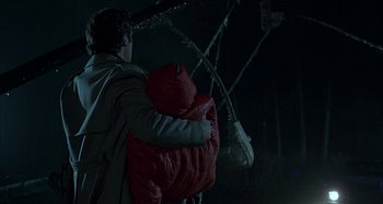 Movie still from “The Ice Storm” (1997), directed by Ang Lee – A man holding a red jacket in the dark; Medium shot, Low angle