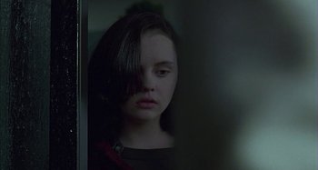 Movie still from “The Ice Storm” (1997), directed by Ang Lee – A woman with a black shirt is looking out of a window; Close Up shot, Over the shoulder angle
