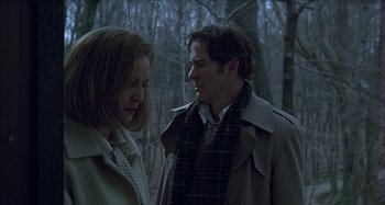 Movie still from “The Ice Storm” (1997), directed by Ang Lee – A man and a woman standing next to each other in the woods; Medium shot, Low angle