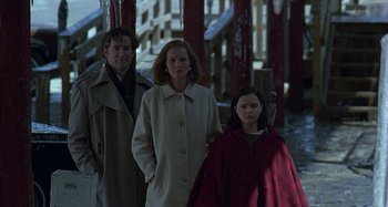Movie still from “The Ice Storm” (1997), directed by Ang Lee – Two adults and a child standing next to each other; Medium shot, Low angle