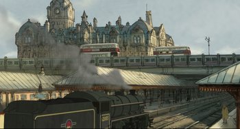 Movie still from “The Illusionist” (2010), directed by Sylvain Chomet – A train traveling down train tracks next to a train station; Extreme Wide shot, Low angle