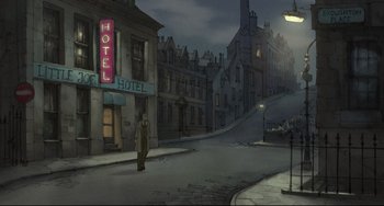 Movie still from “The Illusionist” (2010), directed by Sylvain Chomet – A man standing on the side of a road near buildings; Extreme Wide shot, High angle