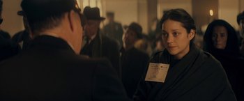 Movie still from “The Immigrant” (2013), directed by James Gray – A group of people standing in a room; Close Up shot, Over the shoulder angle