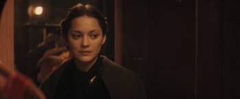 Movie still from “The Immigrant” (2013), directed by James Gray – A woman in a dark room looking to her left; Close Up shot, Over the shoulder angle