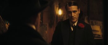 Movie still from “The Immigrant” (2013), directed by James Gray – A man in a suit looking at himself in the mirror; Medium shot, Over the shoulder angle