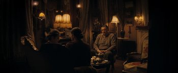 Movie still from “The Immigrant” (2013), directed by James Gray – A group of people sitting around a room; Wide shot, Over the shoulder angle