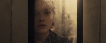 Movie still from “The Immigrant” (2013), directed by James Gray – A woman looking out of a glass window at night; Close Up shot, Over the shoulder angle