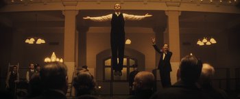 Movie still from “The Immigrant” (2013), directed by James Gray – A man in a suit and tie is flying through the air; Wide shot, Low angle